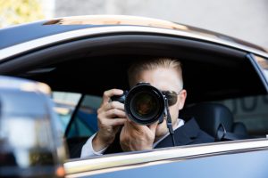 Man Sitting Inside Car Photographing With SLR Camera